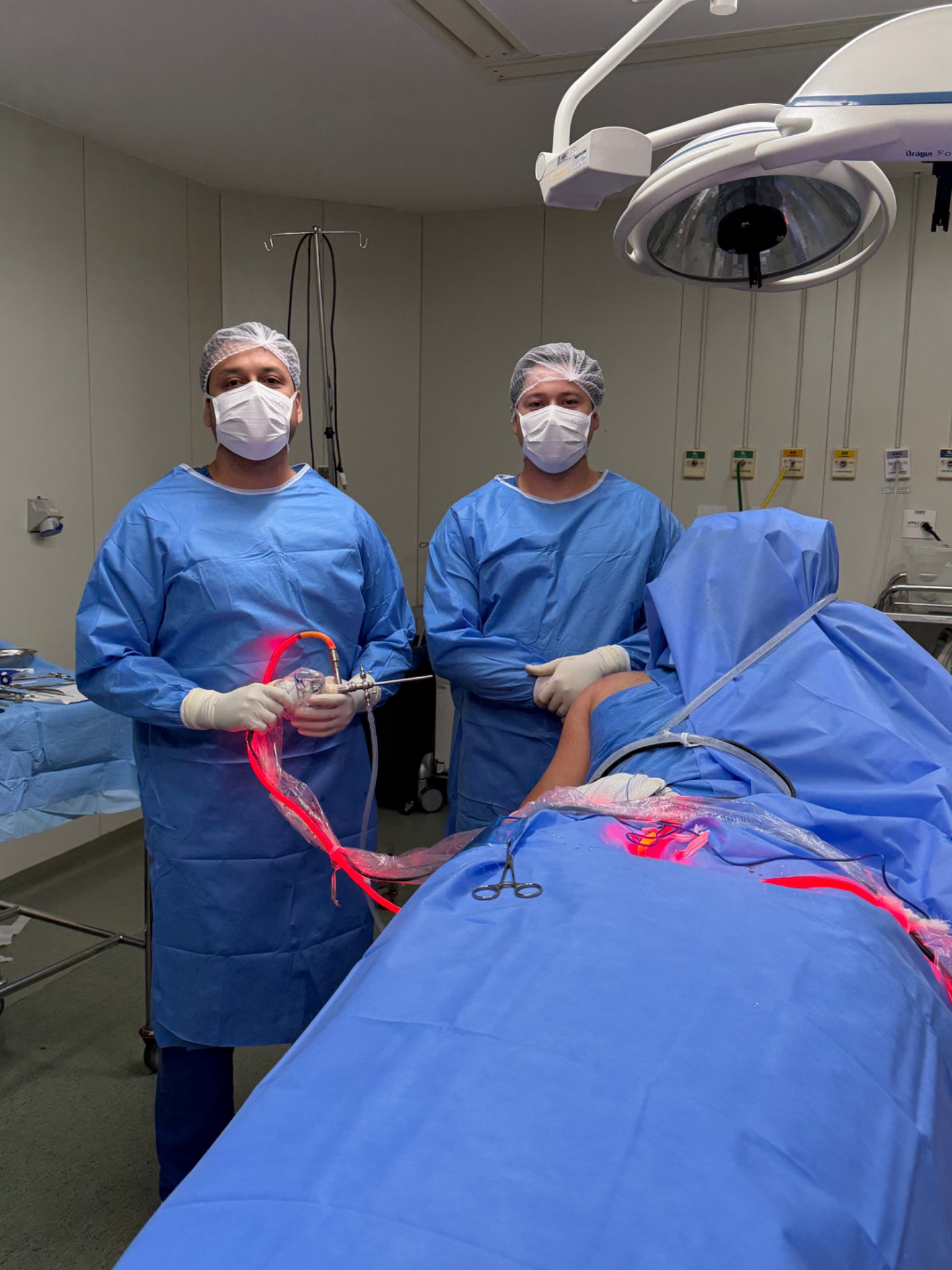 Dr. Vinícius Marques e auxiliar durante uma cirurgia por vídeo do ombro no centro cirúrgico.