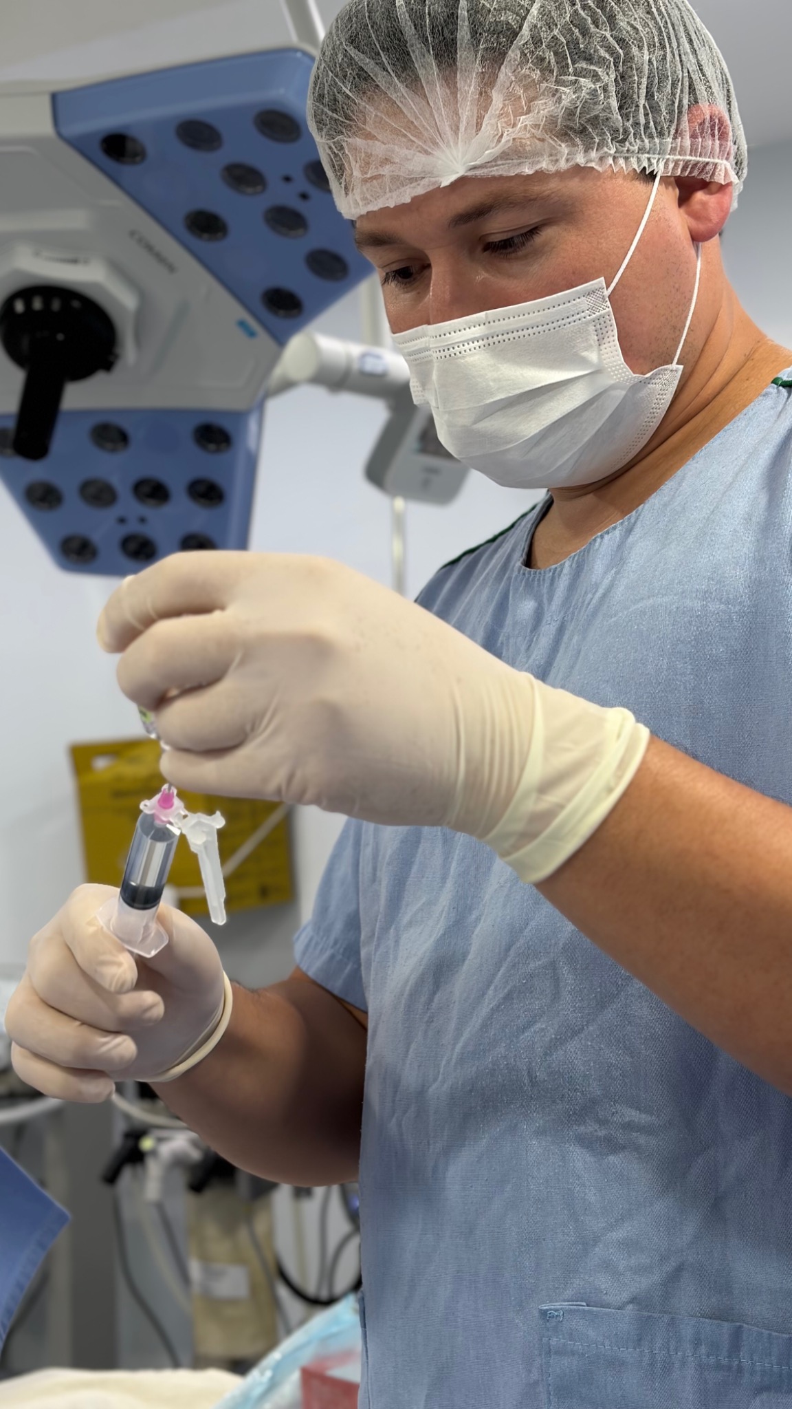 Dr. Vinícius Marques realizando a checagem da medicação para um procedimento no ombro.
